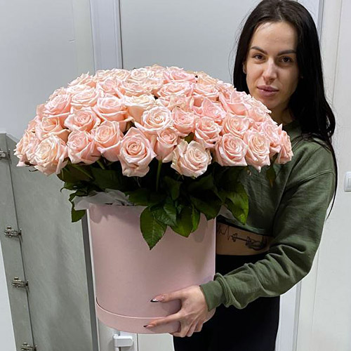 фото букета 101 кремова троянда в коробці в руках одержувачки